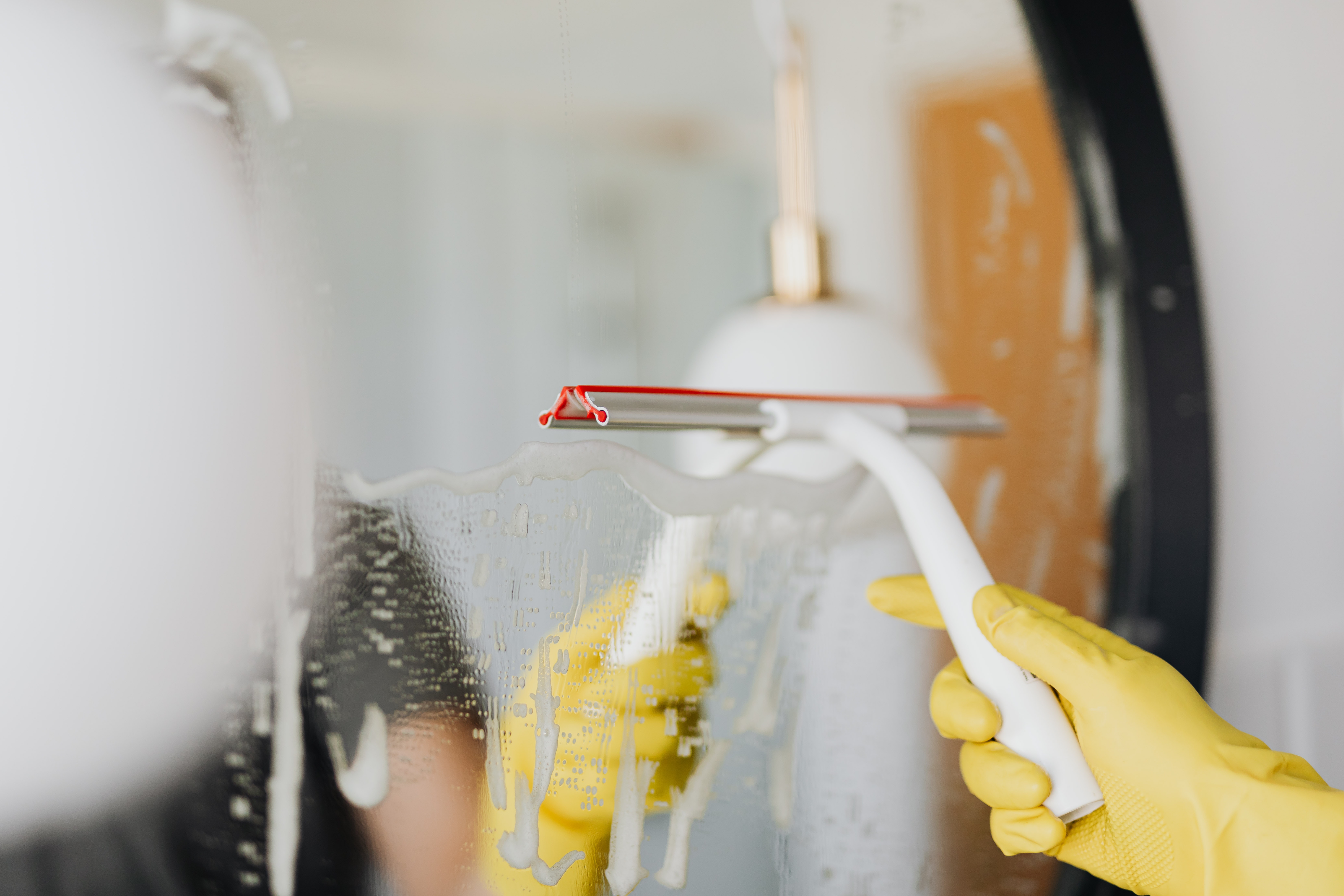 Cleaning bathroom mirror with a squeegee