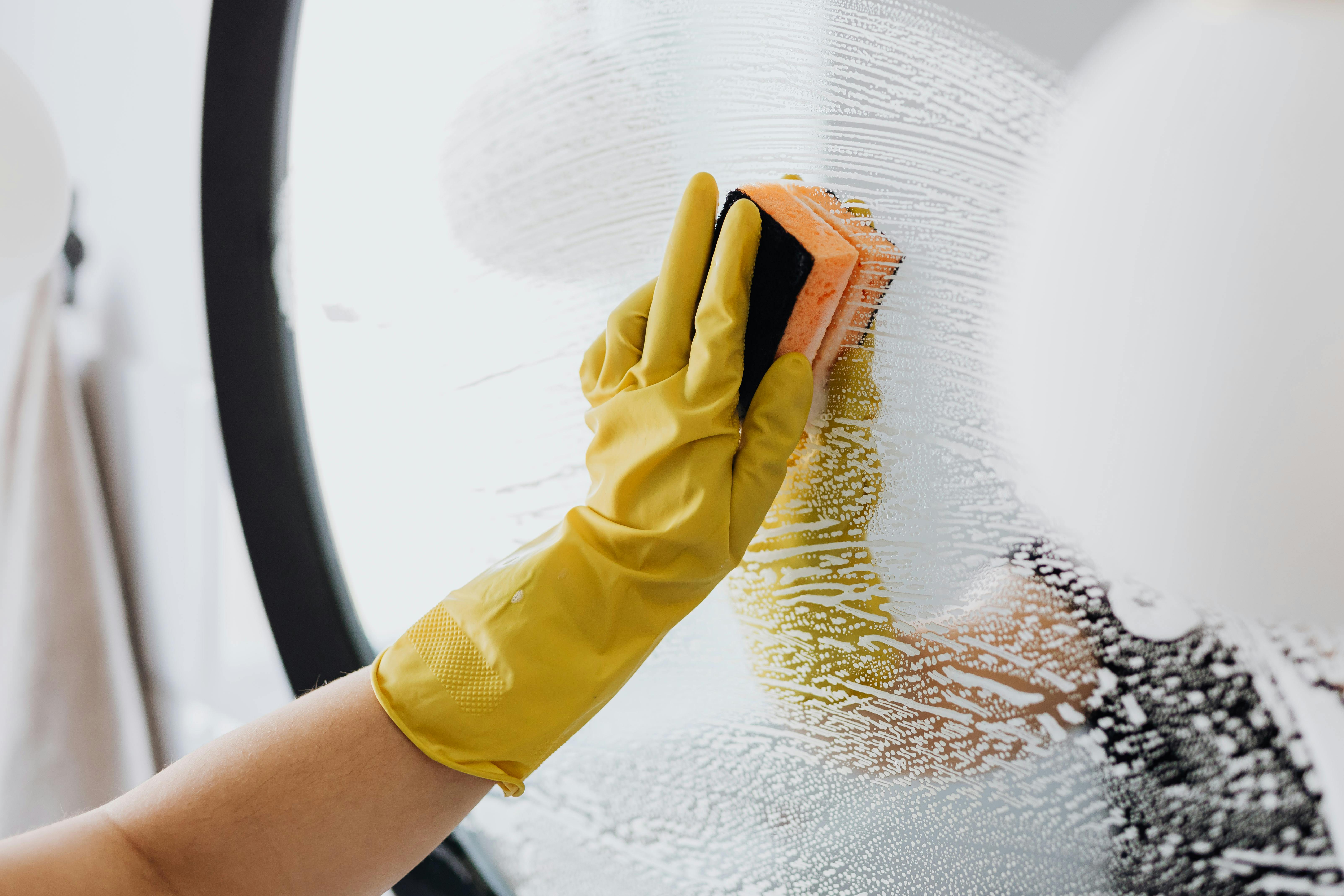 Person scrubbing a bathroom mirror