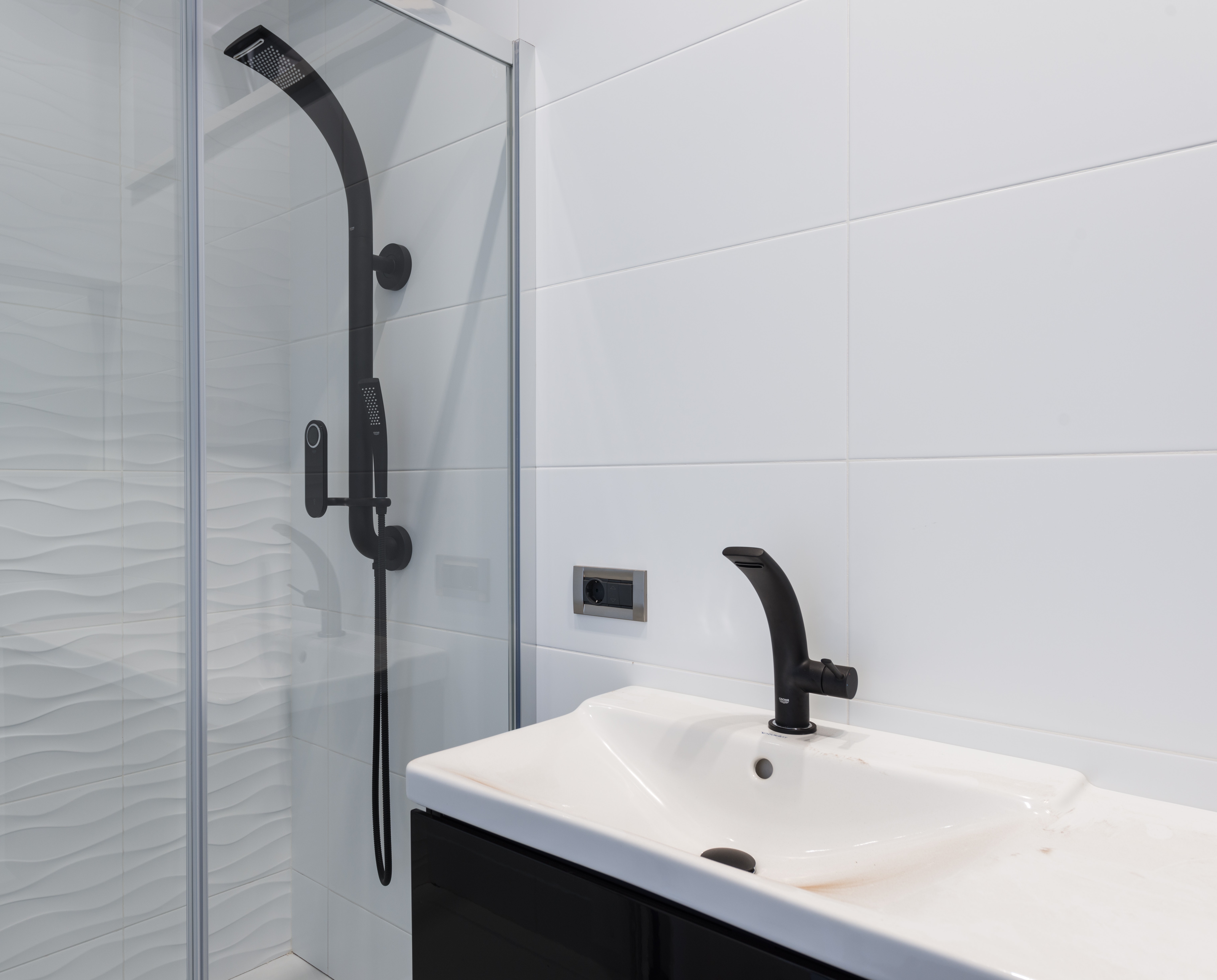 Modern shower enclosure with a sleek matt black shower column