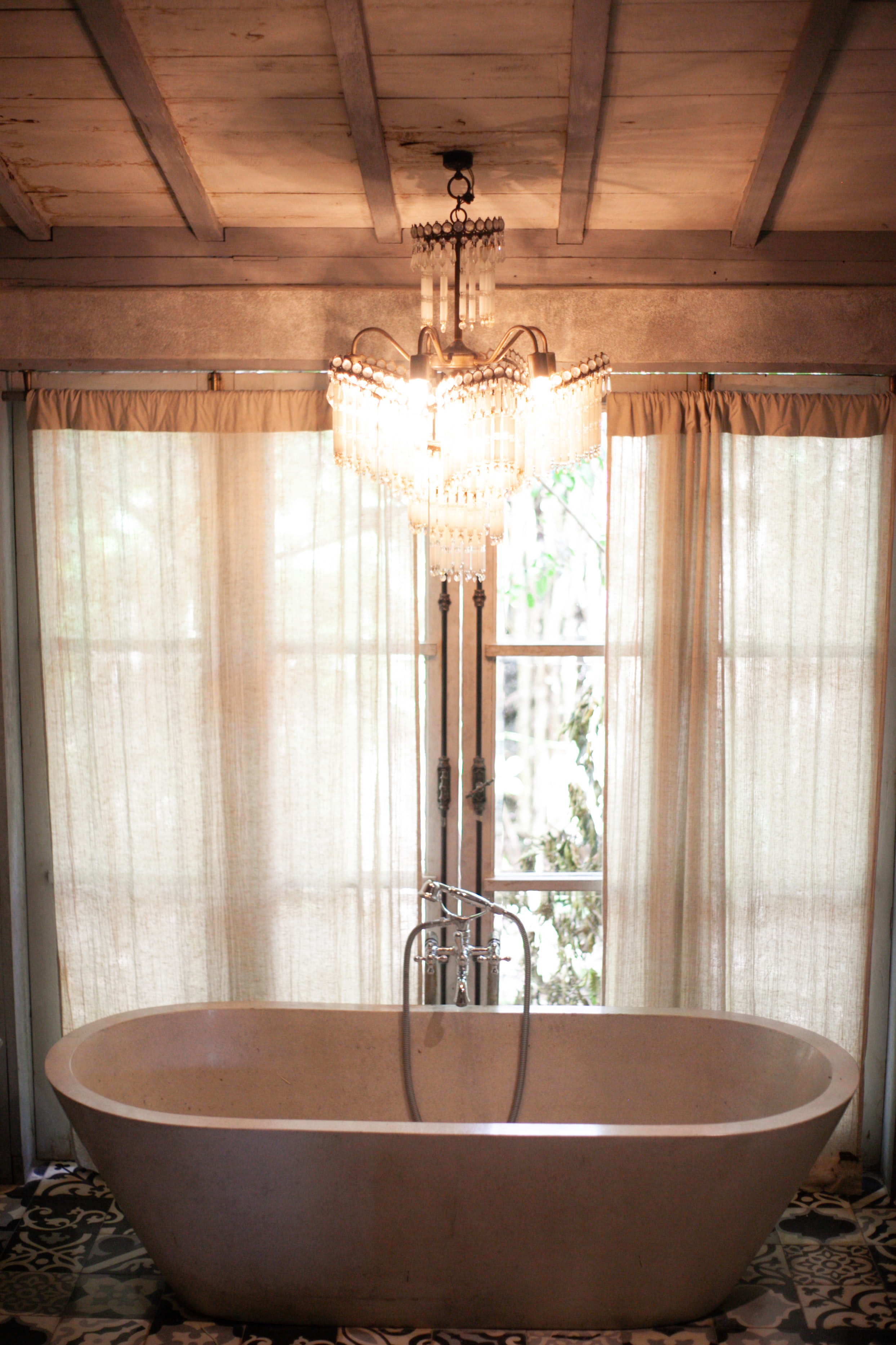 traditional bathroom with bath and an opulent chandelier